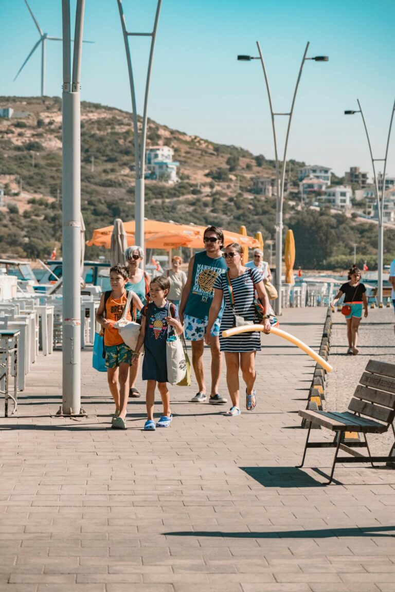 A family enjoying a summer day walking along a scenic waterfront promenade.